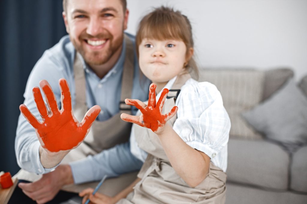 Un père et sa fille atteinte de trisomie ont peint l'intérieur de leur main en orange afin de faire des empreintes de mains